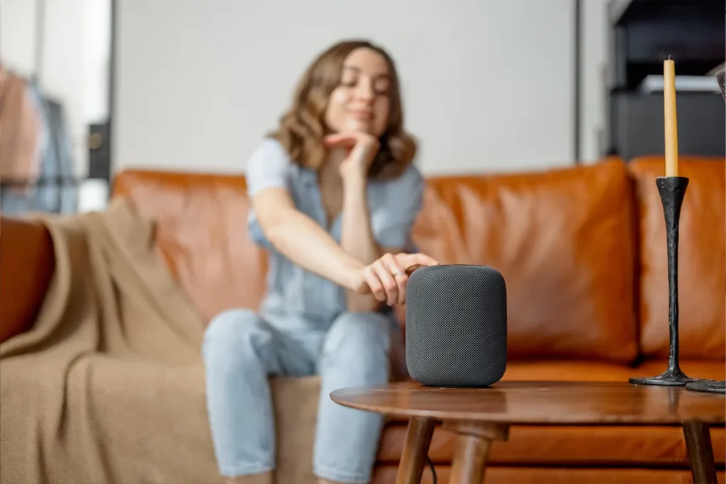 Frau bedient Smart Home Lautsprecher